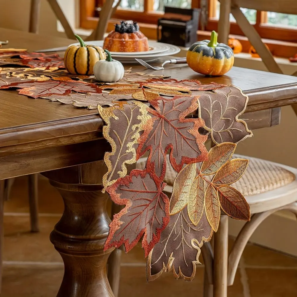 Tischläufer in Blattform mit gestickten Herbstblättern in Braun, Orange und Gold auf einem Tisch