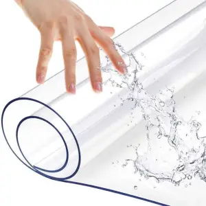 Aufgerollte transparente Tischfolie mit Wasserspritzern und Hand
