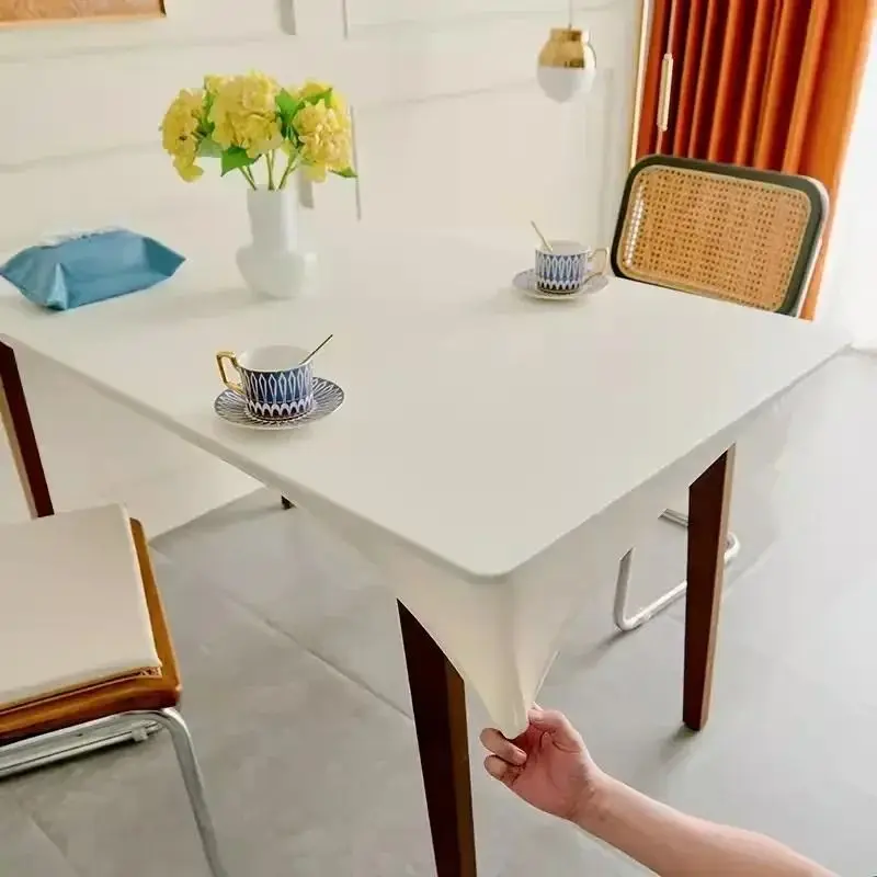 Cremefarbene einfarbige Tischdecke als Spannbezug auf einem Tisch, Gläser und Teller darauf
