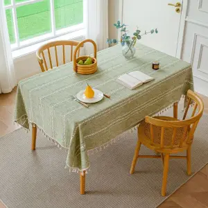 Grüne Tischdecke mit weißen Streifen und Quasten auf rechteckigem Esstisch mit Stühlen