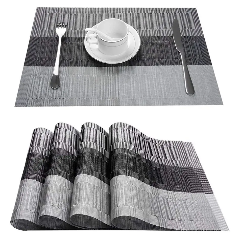 Graue gestreifte Tischsets mit Tasse und Besteck, darunter ein Stapel mit gleichem Streifenmuster